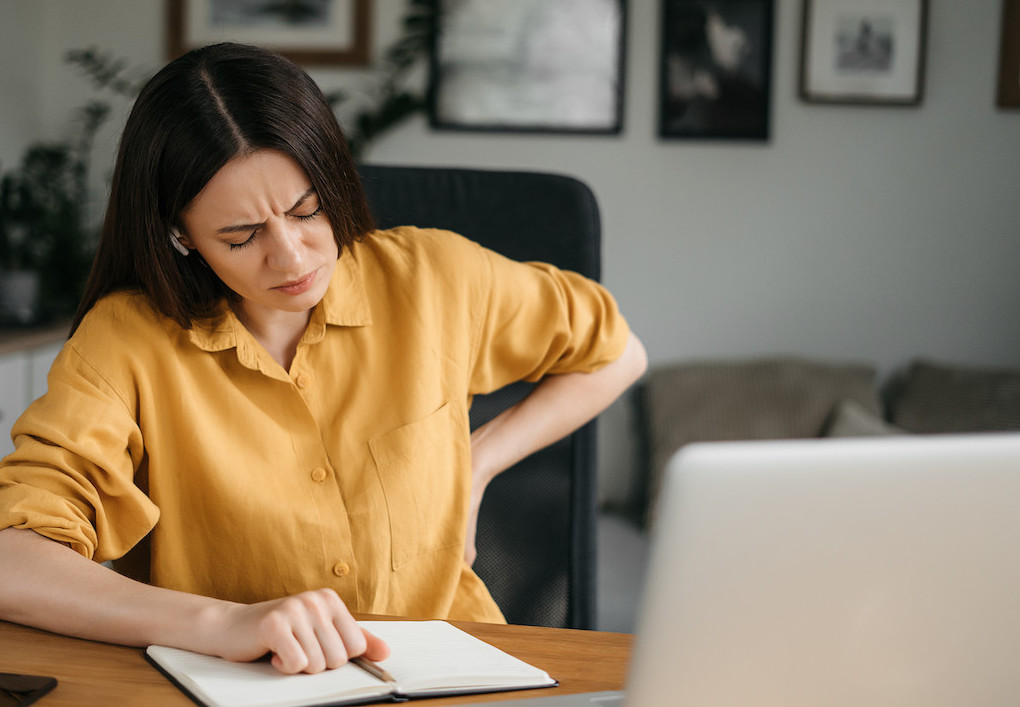 woman having a back pain from poor posture